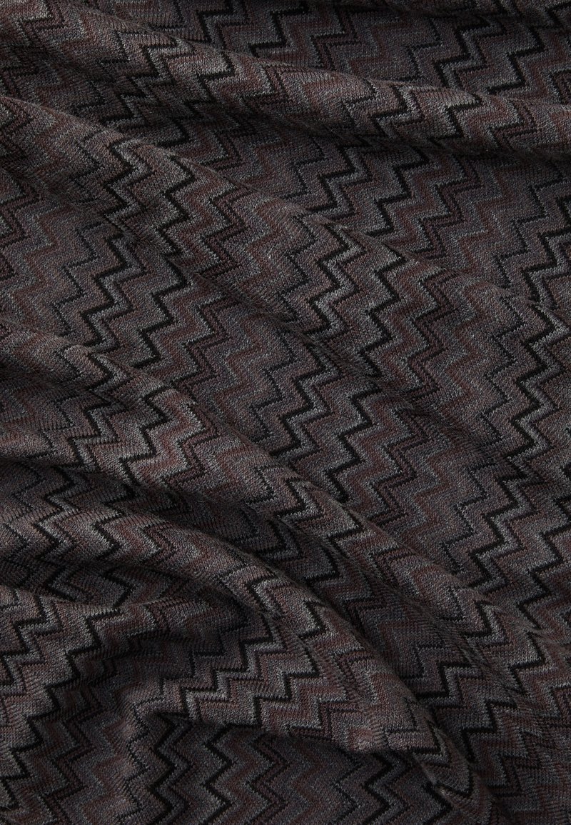Textured fabric in dark brown with black zigzag patterns, showcasing a woven design with soft texture and drape.