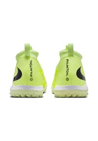 Scarpe da ginnastica di un vivace giallo con design alto, accenti neri e suola testurizzata. Presentano un inserto per facilitare l'indossamento.
