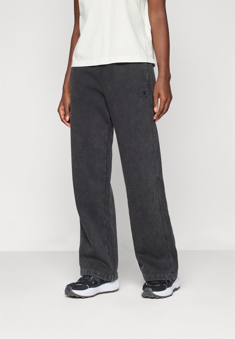 Črne, ohlapne trenirke iz mehke tkanine, z majhnim logotipom na levem stegnu in elastičnim pasom za udobje.