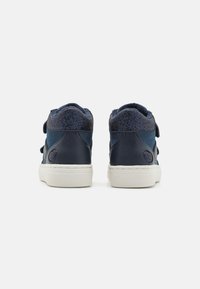 Sneakers alta navy con tomaia in camoscio, tessuto testurizzato attorno al colletto e suola in gomma bianca. Presentano due cinturini in velcro.