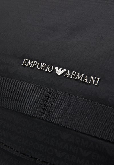 Borsa in tessuto nero con motivo a logo in rilievo, brand "Emporio Armani" in argento e una tracolla nera texturizzata.