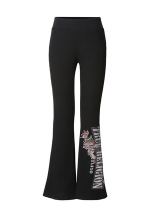 Pantalon noir côtelé évasé avec une large ceinture. Présente un motif floral brodé et un texte imprimé sur la partie inférieure de la jambe gauche.