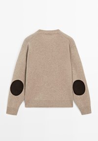 Maglione beige lavorato a maglia con scollo rotondo e orlo a coste. Presenta toppine scamosciate marrone scuro sui gomiti e maniche raglan. Texture liscia.