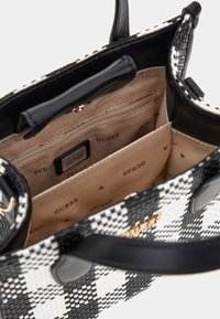Borsa a scacchi bianca e nera con superficie liscia, caratterizzata da una foderatura beige, tasche interne e un dettaglio del logo dorato.