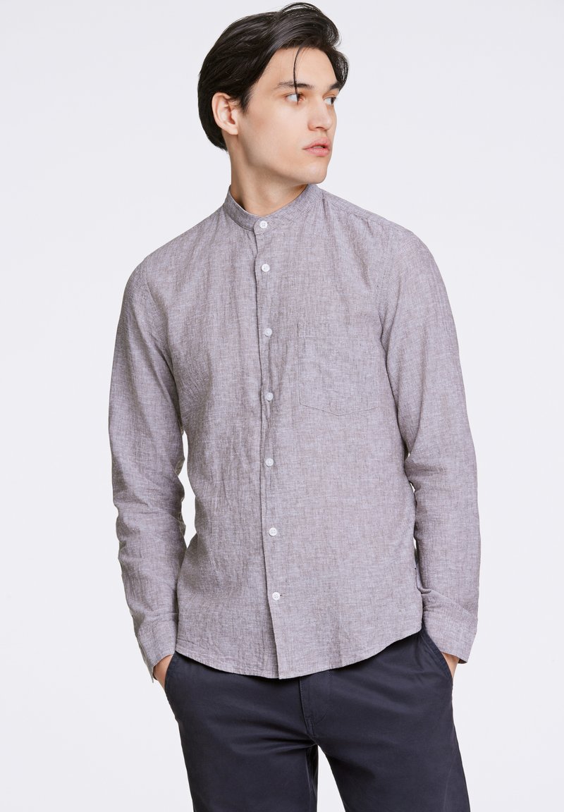 Camicia grigia con colletto, realizzata in tessuto testurizzato, con chiusura a bottoni frontale, maniche lunghe e taschino sul petto. Design slim-fit.