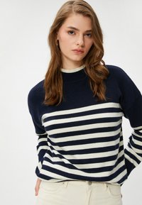 Marineblauwe en witte gestreepte trui met een geribbelde halslijn en lange mouwen. Zachte stof, casual pasvorm en horizontale strepen die over het lichaam lopen.
