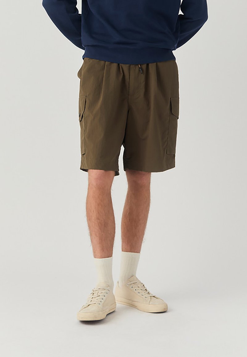 Pantaloni cargo in tessuto verde oliva, con una vestibilità ampia, due tasche laterali e una cintura elastica con cordoncino regolabile.