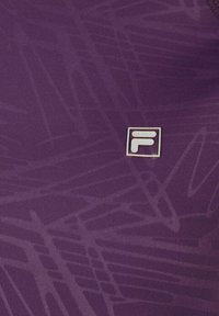 Tela púrpura con patrones lineales abstractos y una pequeña etiqueta con un logo blanco que presenta una "F" estilizada en el centro.