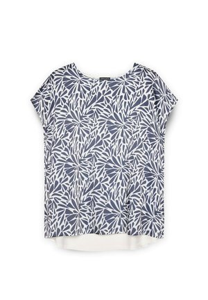 Top alb cu maneci scurte, prezentând un model de frunze în nuanță de bleumarin, guler rotund, croială lejeră și o margine din spate ușor mai lungă, cu o textură netedă.