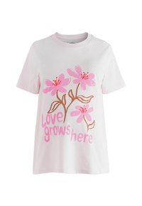 Weißes Baumwoll-T-Shirt mit floralem Motiv aus pinken Blumen und braunen Stielen. Text "love grows here" in pinker, stilisierter Schrift. Kurzärmlig.