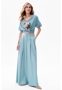 Ensemble bleu clair composé d'un haut à manches courtes noué avec un imprimé graphique et d'un pantalon large plissé taille haute.