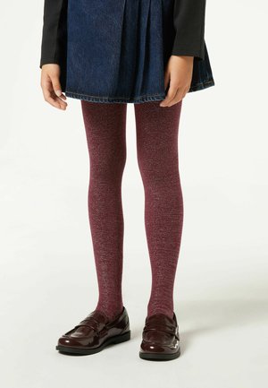 Collant glitter bordeaux con una texture liscia, indossati sotto una gonna di jeans, abbinati a mocassini bordeaux lucidi.
