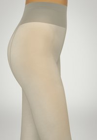 Beige sømløse leggins med en blød, strækbar tekstur. Høj talje i en lys grå farve. Glat, kropsnær design. Ingen synlige sømme.