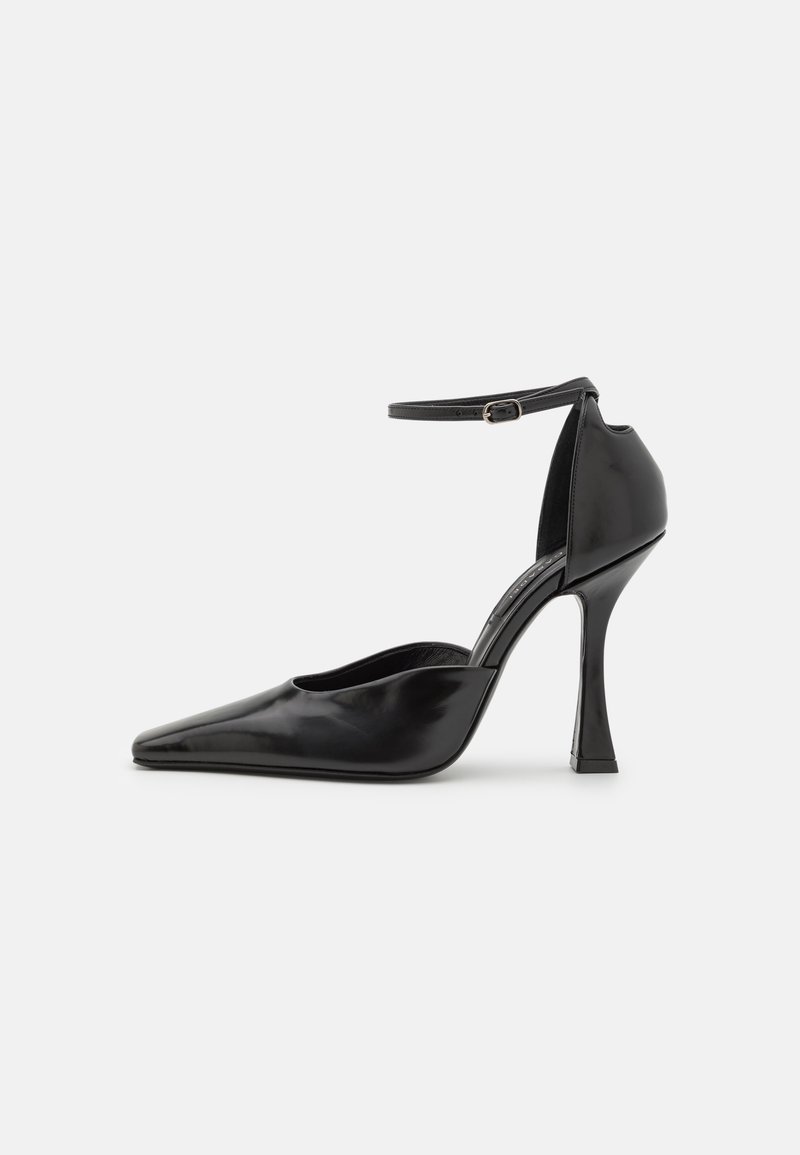Sort højhælet pumpe med en blank finish, spids tå, ankelrem og en sculptet stiletto hæl. Glat tekstur og strømlinet design.