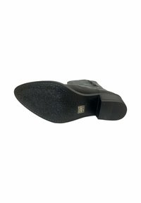 Bota negra de tacón con suela de goma texturizada, punta redondeada, parte superior de cuero suave y detalle de cremallera lateral para facilitar su uso.