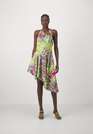 Vestido asimétrico tipo halter que presenta una vibrante mezcla de patrones en verde, rosa y púrpura, confeccionado en una tela ligera con una silueta fluida.