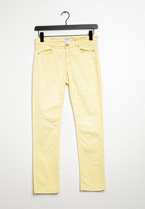 Lichtgele slim-fit broek met knopen aan de voorkant en zakken, hangend aan een zwarte hanger tegen een witte achtergrond.