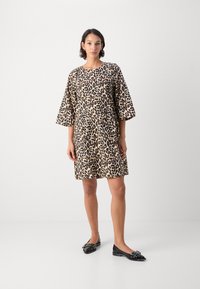 Haljina sa leopard uzorkom, tri četvrtine rukava, lagani materijal, širokog kroja, do sredine bedara, u kombinaciji s crnim balerinkama s kopčama.