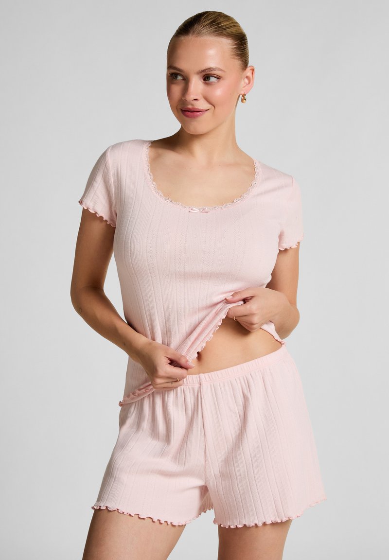 Lichtroze, geribde loungewear set met een top met korte mouwen, kantafwerking en strikaccent, gecombineerd met bijpassende shorts met onderborden.