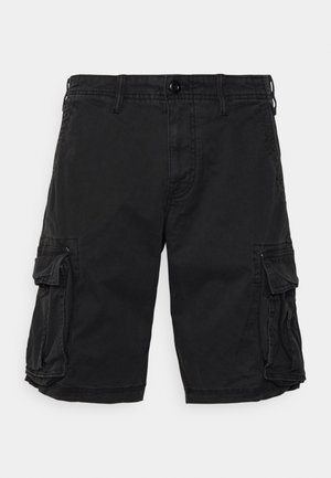 Zwarte cargo shorts tot op de knie met knoop aan de voorkant, lussen voor een riem, zijzakken met klep en zichtbare stiknaden op een effen achtergrond.