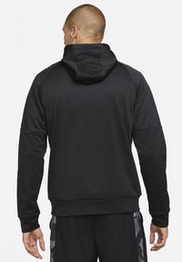 Sudadera negra con capucha, de textura suave y mangas raglán. Cuenta con un bolsillo tipo canguro y puños acanalados en el dobladillo y las mangas.