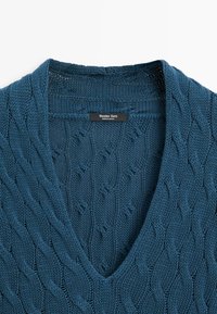 Pull bleu à col en V en maille torsadée avec motif texturé et étiquette "Massimo Dutti Made in Spain" à l'intérieur du col.