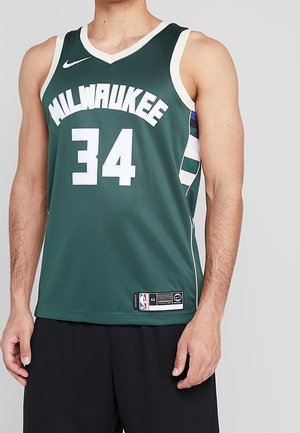 Maillot de basketball vert avec le texte blanc "MILWAUKEE" et le numéro "34". Présente le logo Nike et des rayures horizontales bleues et blanches sur le côté.