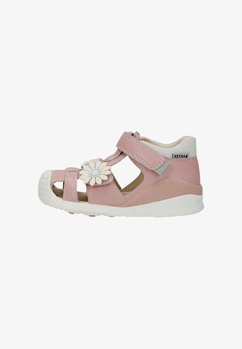 Sandale enfant rose avec semelle en caoutchouc blanche, bride velcro, bout ouvert et fleur blanche décorative sur le côté sur fond blanc.