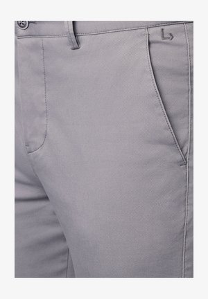 Szare spodnie materiałowe o gładkiej fakturze, z kieszonką z przodu, zapięciem na guzik i subtelnymi fasonami przeszyć.