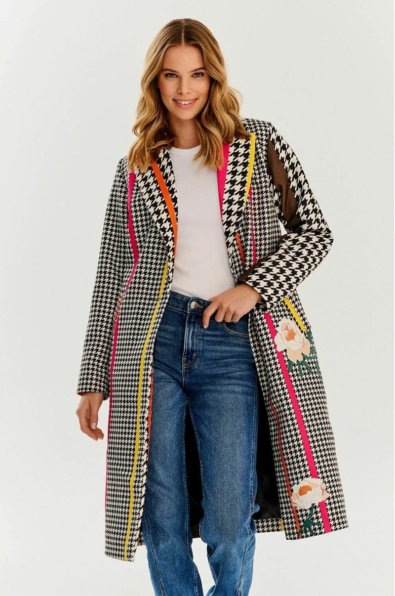 Płaszcz w wzór houndstooth w czarno-białych kolorach, z wyrazistymi akcentami w różowym, pomarańczowym i żółtym, z kwiatowymi detalami. Długie rękawy i długość do kolan.