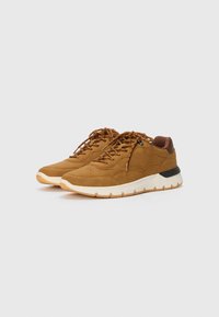 Brown suede sneakers with textured surface, round toe, contrasting white sole, and braided laces. Black accent on the heel.
