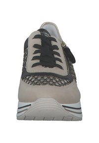 Sneaker beige e nera con una parte superiore in mesh texturizzato, chiusura a lacci e zip laterale. Presenta una suola imbottita con un sottile motivo a righe.