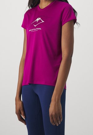 Person wearing a magenta short-sleeve shirt with white mountain logo and text "ASICS FUJITRAIL" paired with navy blue leggings.