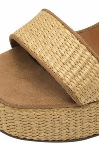 Sandali platform in paglia intrecciata con una larga cinghia in pelle marrone e una soletta morbida simile alla suede, caratterizzati da una texture intrecciata e una suola piatta.