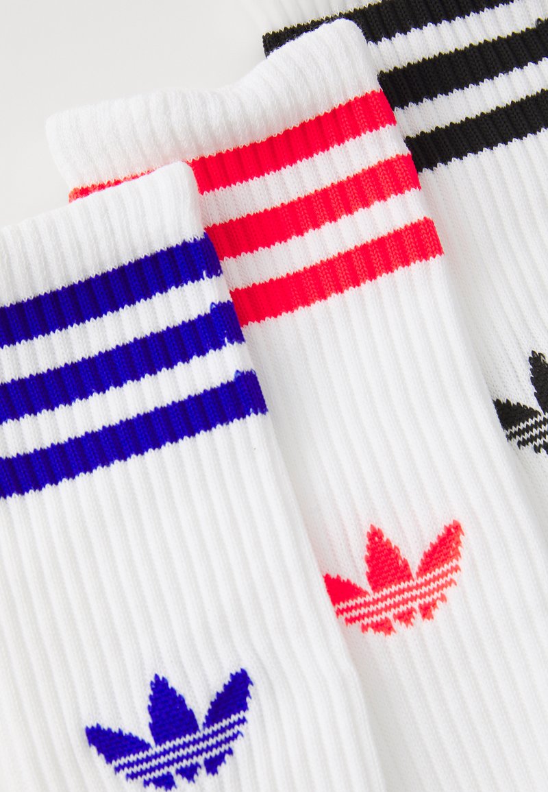 Calzini bianchi a coste con tre righe: blu, rosso e nero, con loghi colorati corrispondenti alla caviglia.