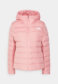 Veste matelassée rose avec capuche, dotée d'une fermeture éclair sur le devant, d'un motif matelassé horizontal et d'un logo sur le côté supérieur gauche.