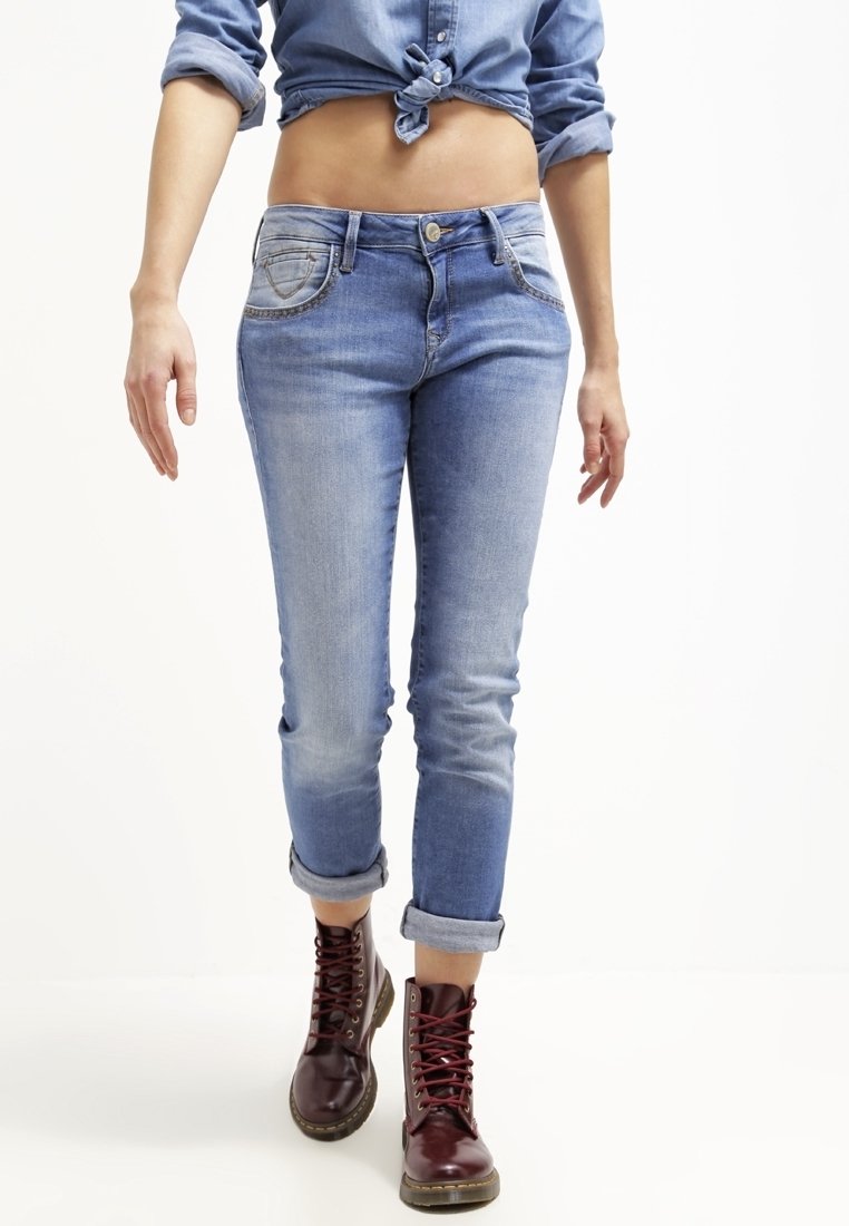 Světle modré džíny s přiléhavým střihem, ohrnutými lemy a dvěma předními kapsami. Doplněné vínově červenými šněrovacími botami.