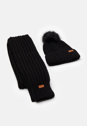 Black knitted scarf and beanie set. Scarf features a ribbed texture, while beanie has a pom-pom on top and a label accent.