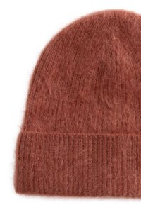 Knit beanie in terracotta, made of soft, fuzzy material. Features a wide ribbed cuff at the bottom and a rounded top.