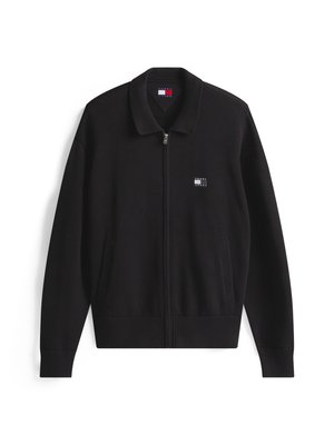 Black knitted cardigan with a zip closure, a collar, two side pockets, and a small logo patch on the left chest. Textured fabric.