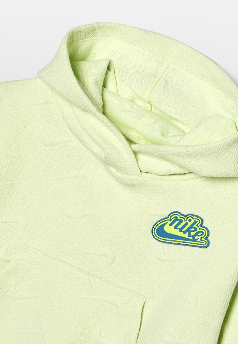 Haut à capuche vert clair en tissu texturé, avec une poche avant et un patch de logo Nike bleu en accent sur la zone de la poitrine.