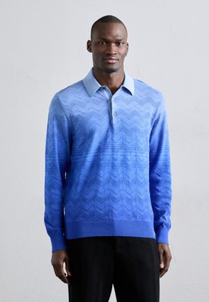 Sinine pikakä sleeves polo, millel on gradientne chevronsinine muster, varustatud krae ja kolme nööbiga. Valmistatud tekstuurist kangast.