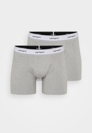 Pelēki kokvilnas bokseršorti ar melnbaltu gumiju, kurā ir teksts "carhartt". Izstādītas divas pāri. Mīksta auduma, pieguļošs dizains.