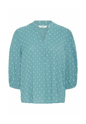 Lichtblauwe blouse met een V-hals, ingewikkeld stippenpatroon en ballonmouwen. Gemaakt van zachte stof met een relaxte, vloeiende pasvorm.