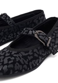 Zwarte balletschoenen met een suede afwerking, voorzien van een textuur met luipaardprint, elastische band en een gesp-accent. Glad zwarte binnenvoering.