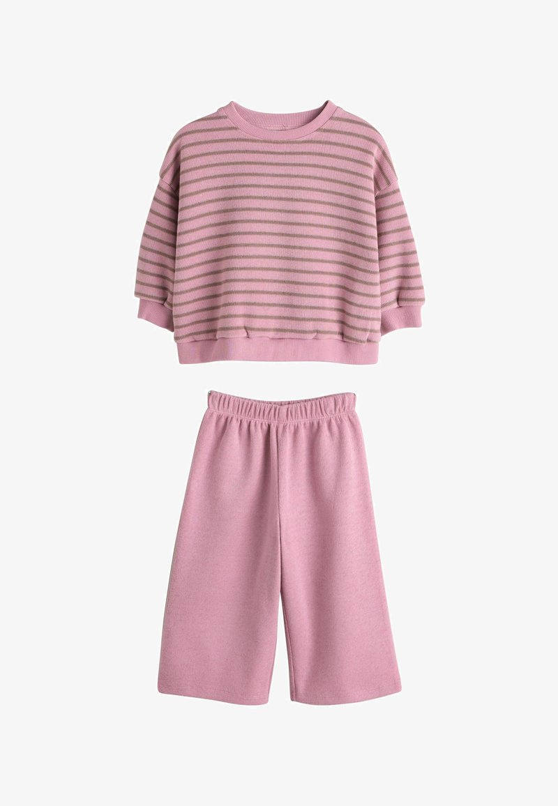 Pull court rose avec rayures horizontales marron clair, associé à un short rose assorti avec une ceinture élastique. Texture de matériau douce.