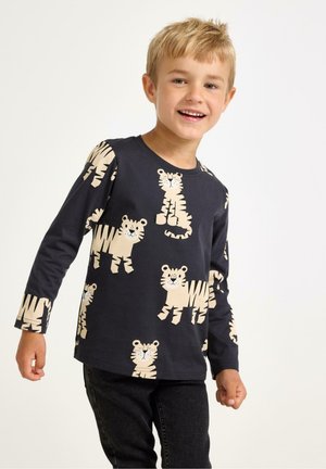 Langærmet navy T-shirt med et legende mønster af lysecreme tigre. Lavet af blødt bomuld med rund halsudskæring og afslappet pasform.