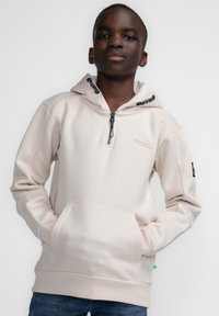 Lichte beige hoodie met een ritskraag, een kangaroo pocket en zwart gestreepte koordjes. Heeft ribgebreide mouw- en zoomboorden.