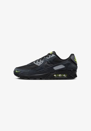 Basket noire et grise en matériaux suédine et en maille, dotée d'un amorti Air Max, d'accents verts et d'une semelle extérieure en caoutchouc durable.