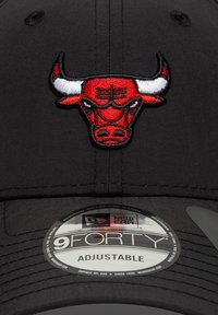 Μαύρο ρυθμιζόμενο καπέλο με κεντημένο κόκκινο και λευκό λογότυπο ταύρου. Περιλαμβάνει κυκλικό ετικέτα με την ένδειξη «9FORTY» στην κάτω πλευρά.